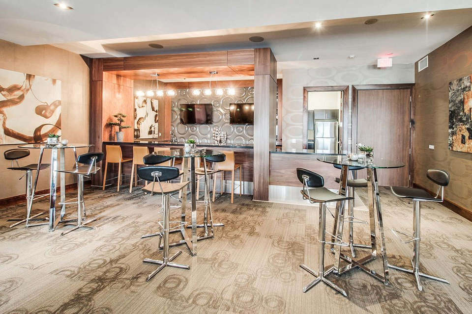Custom millwork, wall panels, cabinetry, bar counter, in a lounge bar in luxury condominium party room in Waterloo Ontario.